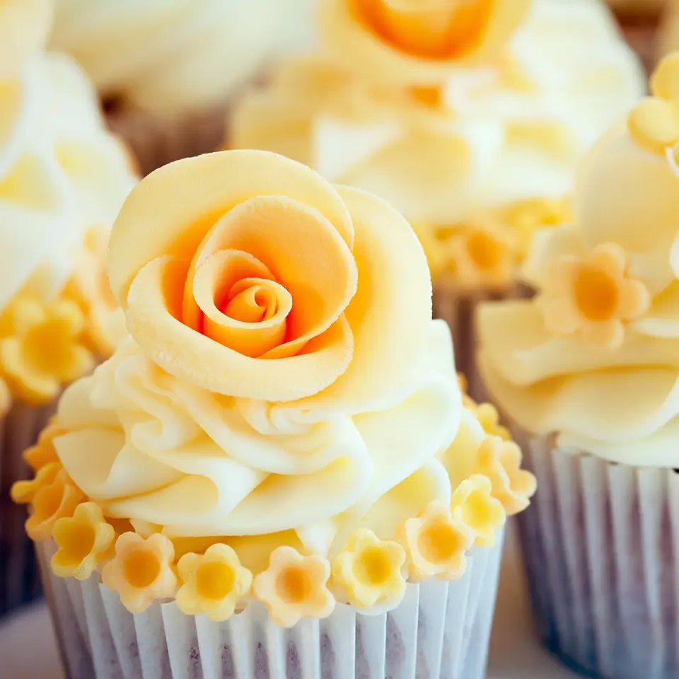 Yellow cupcakes with sugarpaste flowers on top