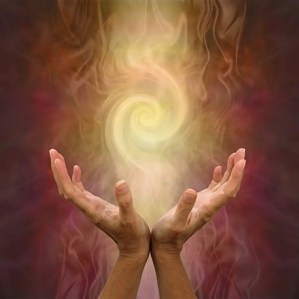 Channeling Golden Vortex healing energy - female hands held open and palms upwards with a vortex energy formation above on a warm golden brown background