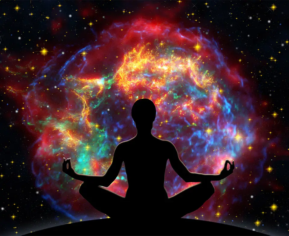 Person in a cross-legged meditation pose in front of cosmic background