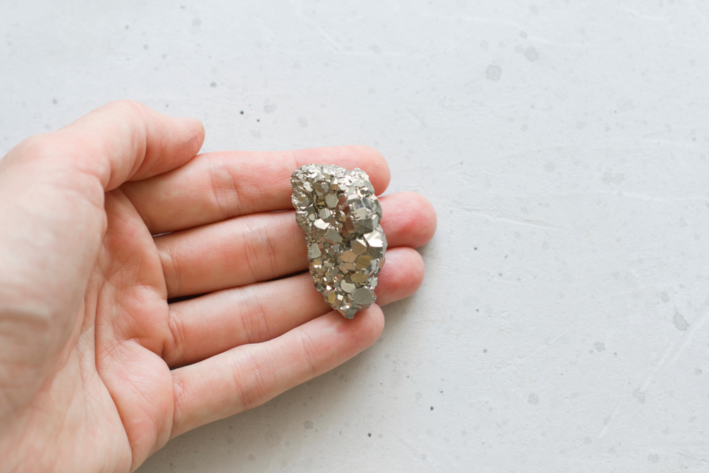 Someone holding a piece of Pyrite