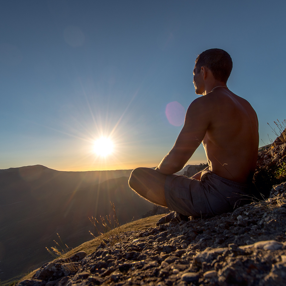 Man meditating on a mountain