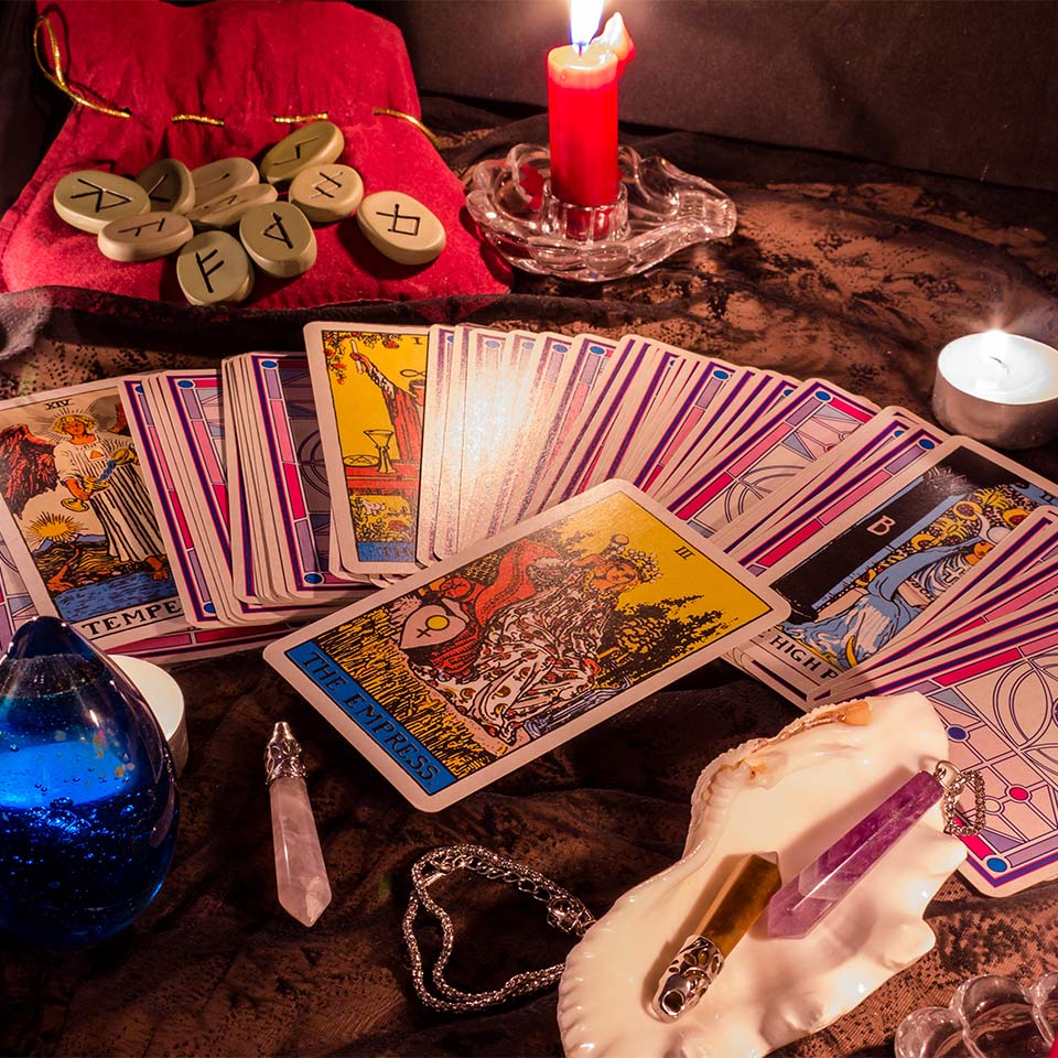 A ring of tarot cards alongside crystals