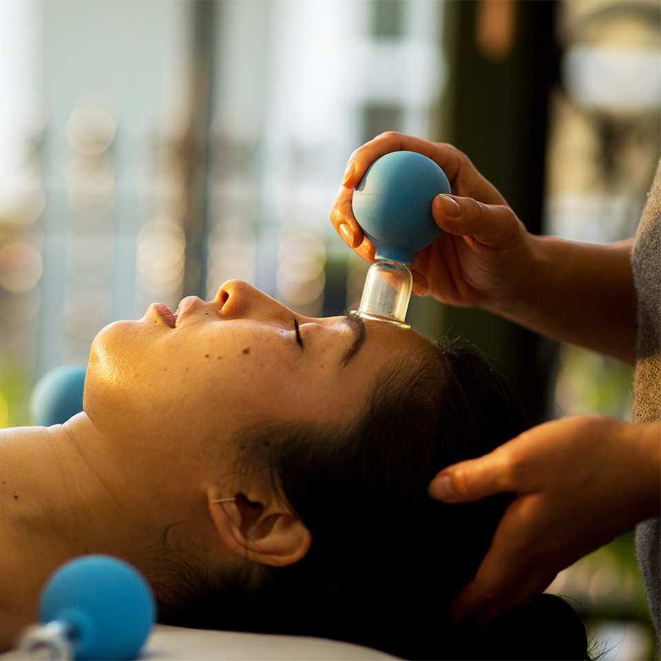 Woman receiving facial cupping massage at a spa