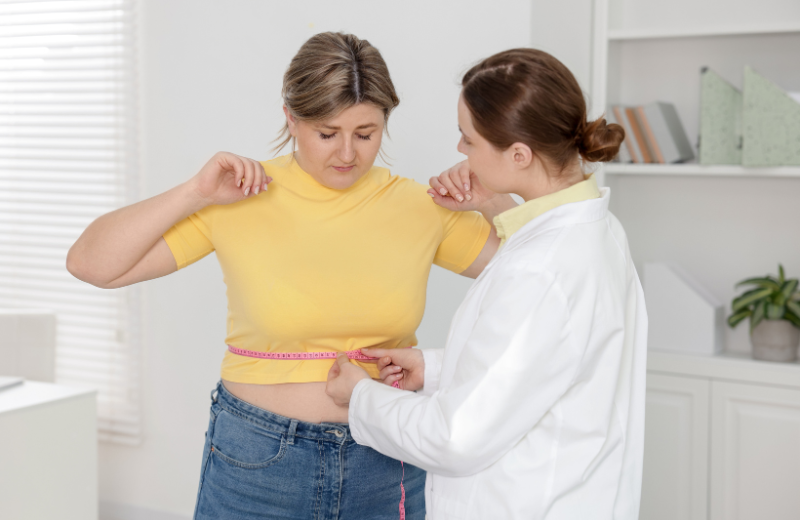 woman having stomach measured by doctor