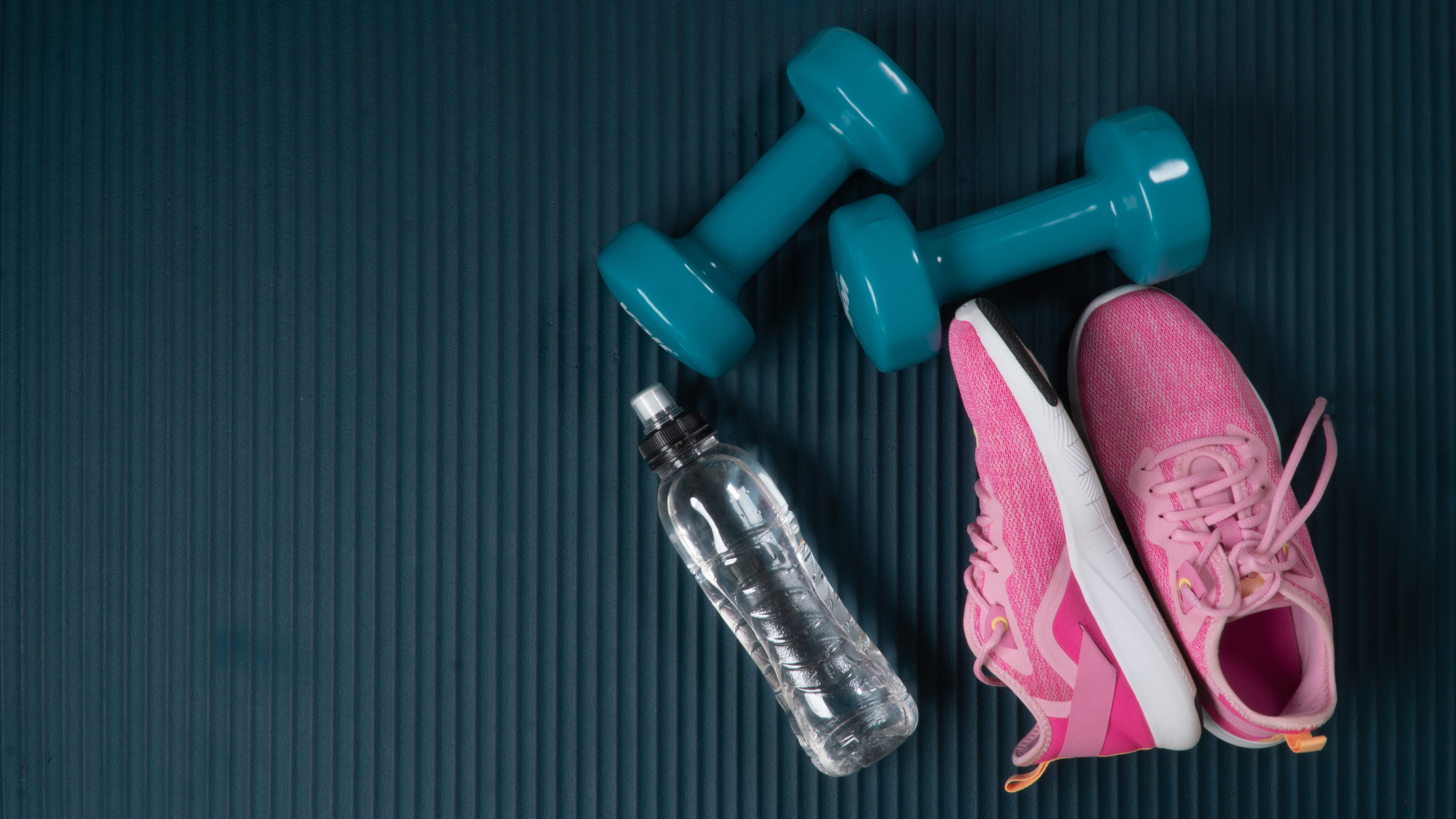 Workout equipment flat lay, trainers and weights and water bottle