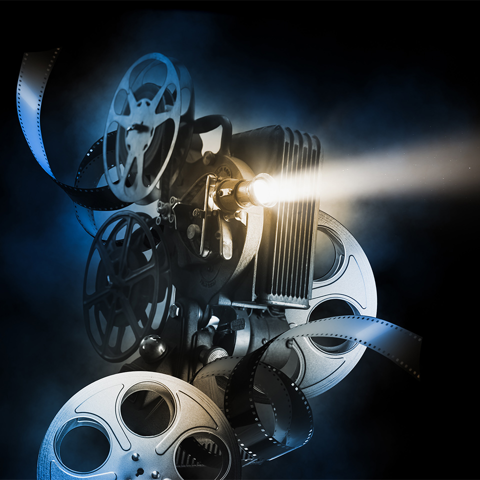 Movie projector and film reels on a dark background