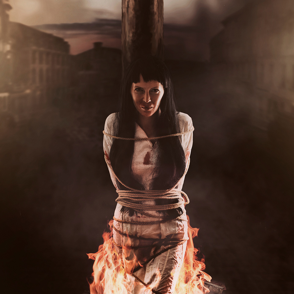 A woman tied to a post and being burned at the stake as a witch