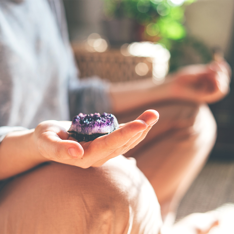 Woman meditating with a crystal in her hand