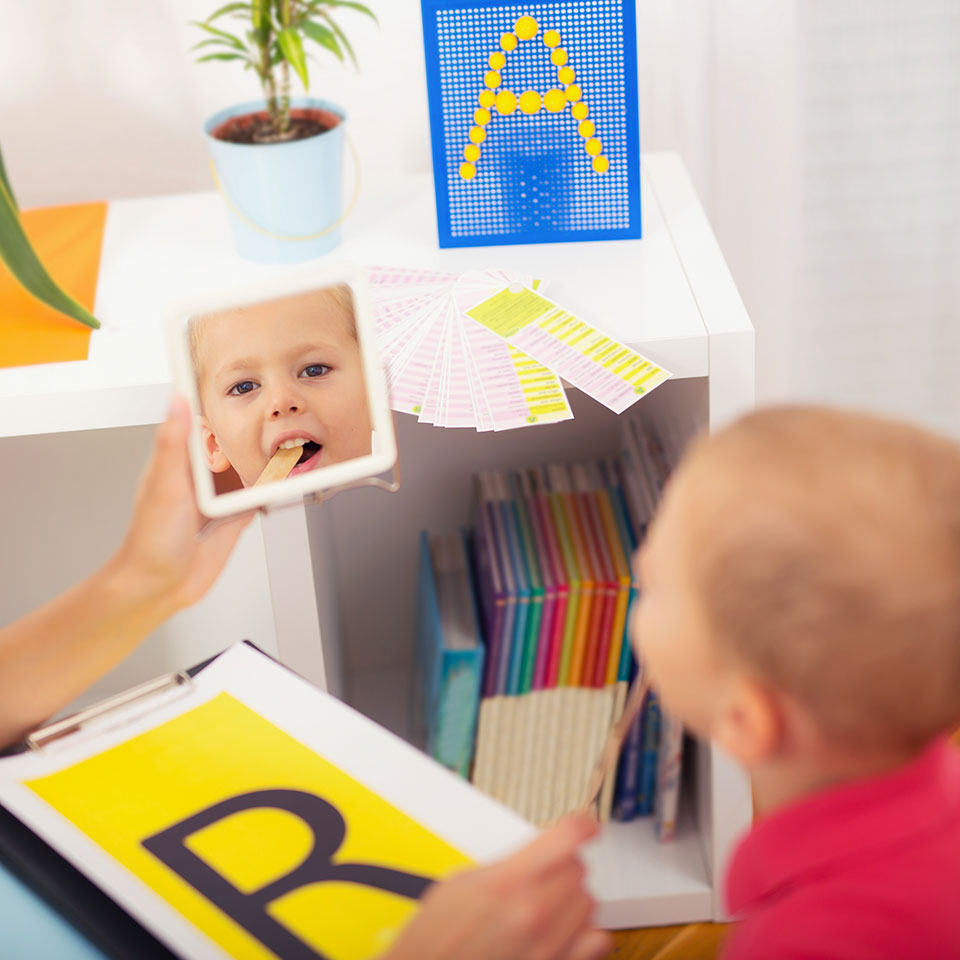 Child looking in the mirror and learning to make an 'r' sound