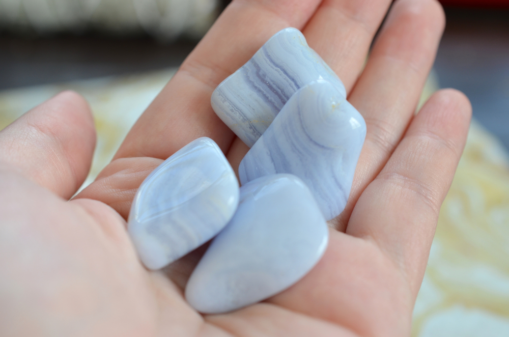 Four pieces of Blue Lace Agate in the palm of a hand