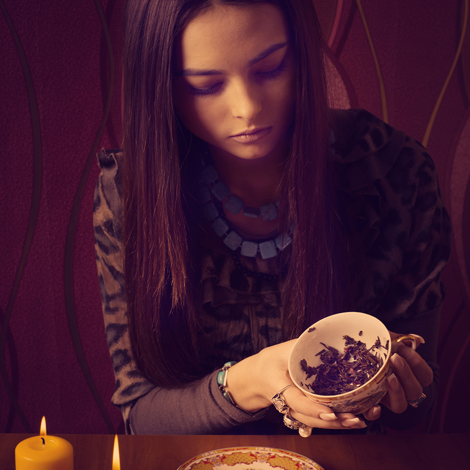 Woman doing a tea leaves reading.