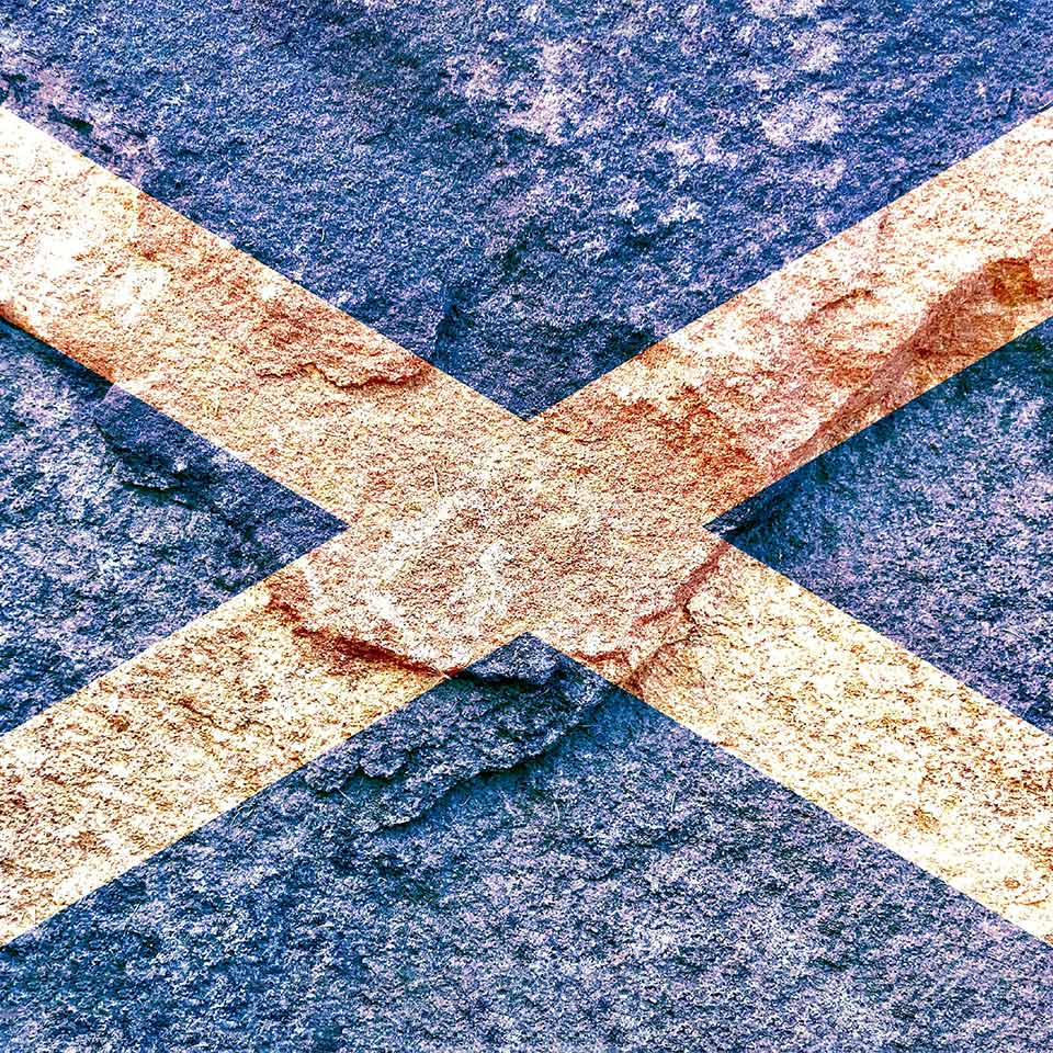 Vintage Scotland national flag on weathered rock wall