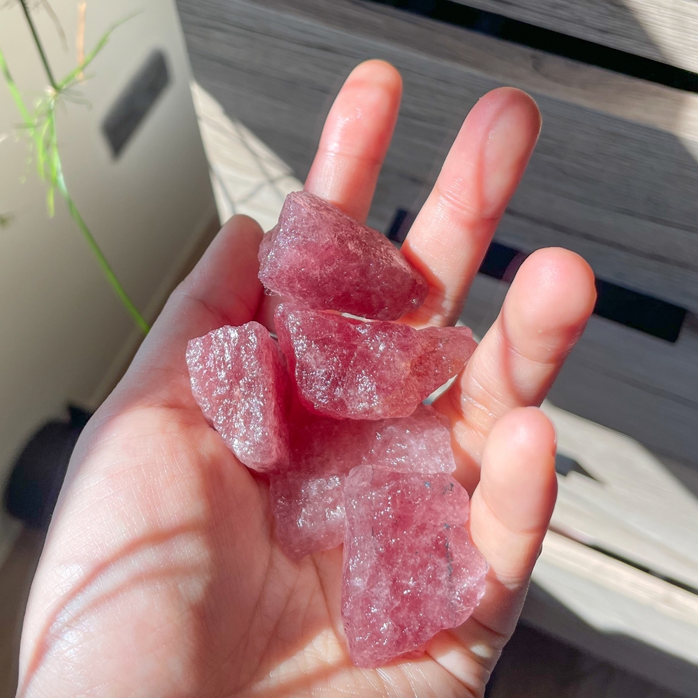 Pieces of Strawberry Quartz in someones hand
