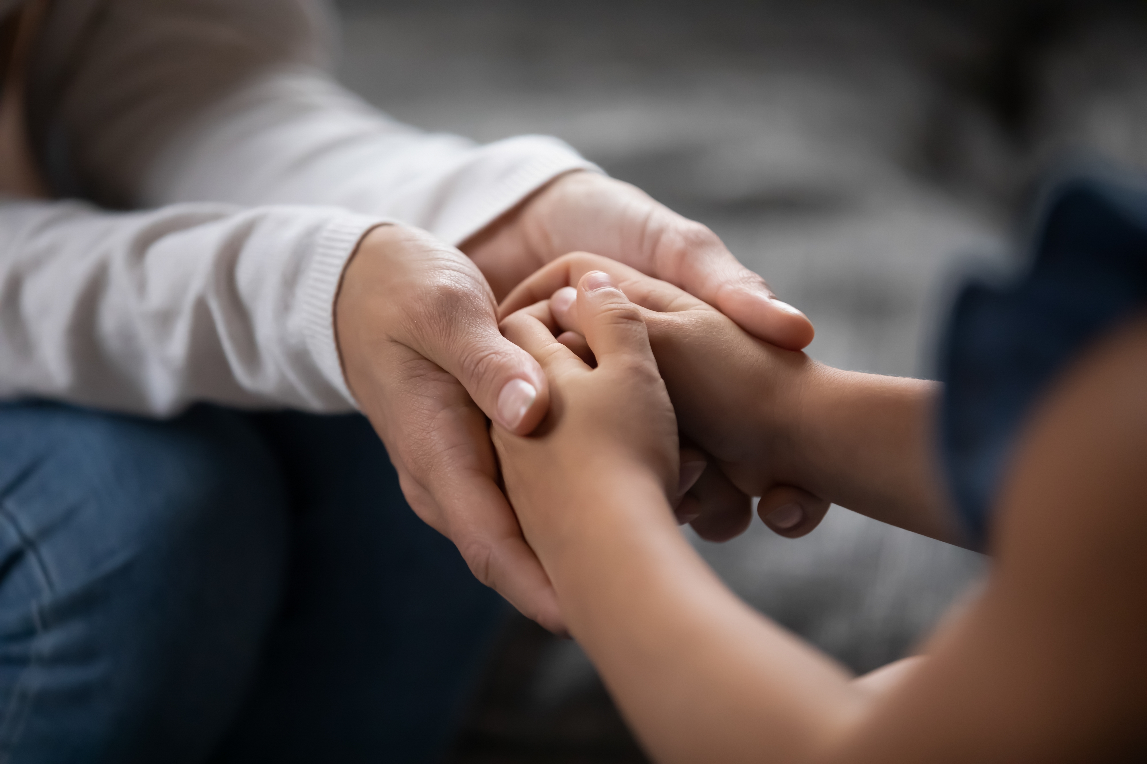 A close up of an adult holding a child's hands