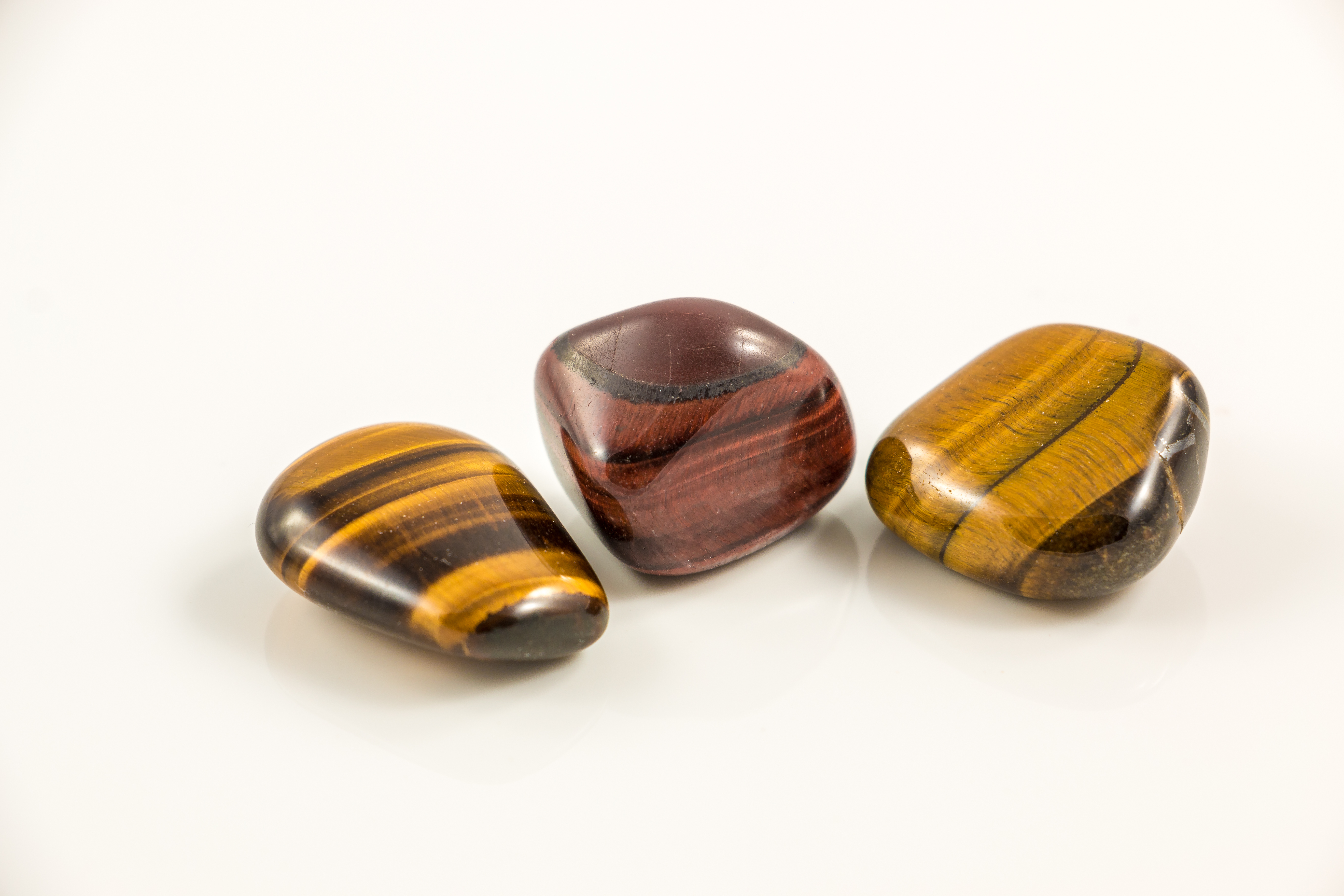 Three pieces of Tiger's Eye on a white background