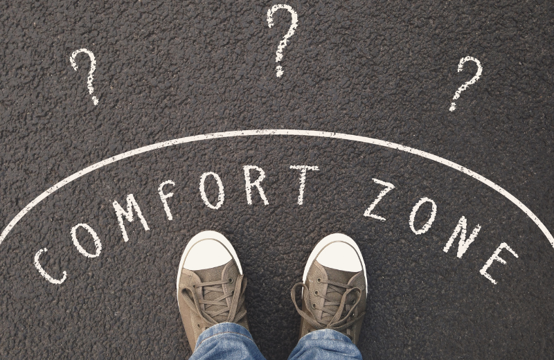 Image of 'comfort zone' written around someone's feet.