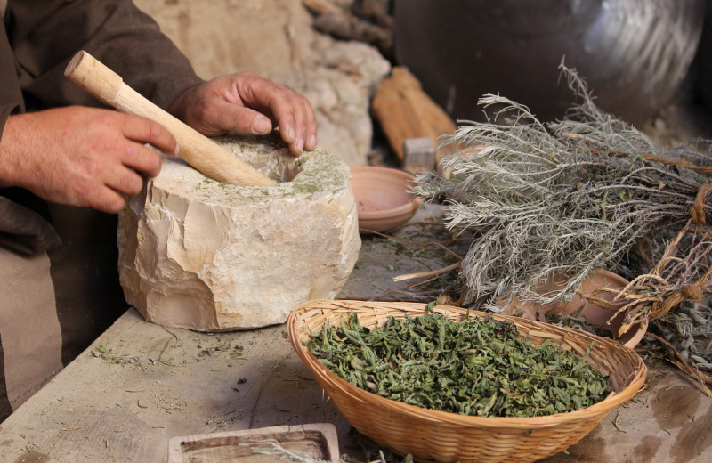 person grining Skullcap with pestle and mortar