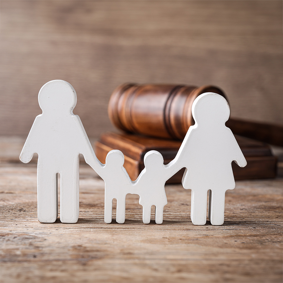 Figures of a family and gavel on a wooden table