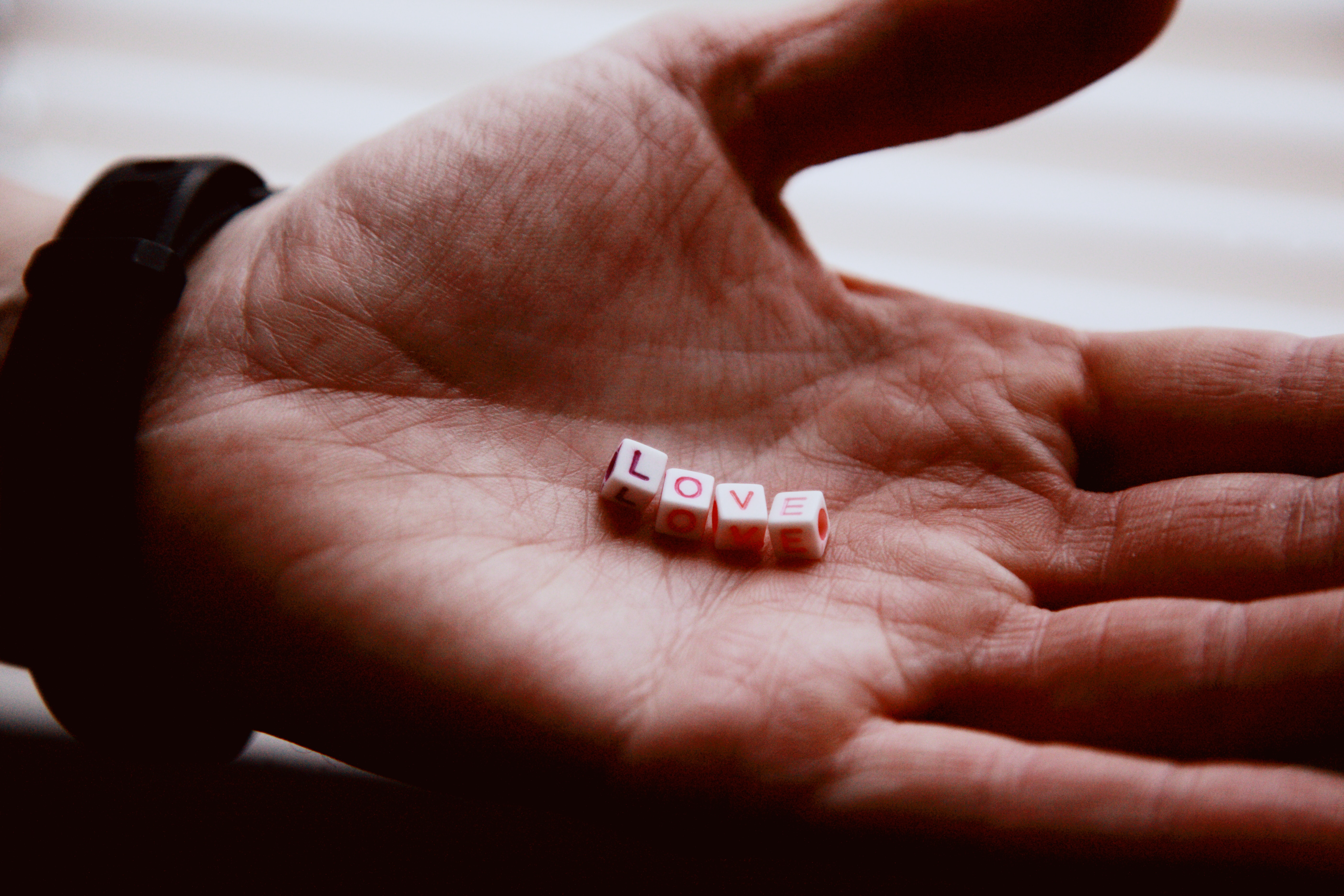 A hand with small blocks on it spelling out the word "love"