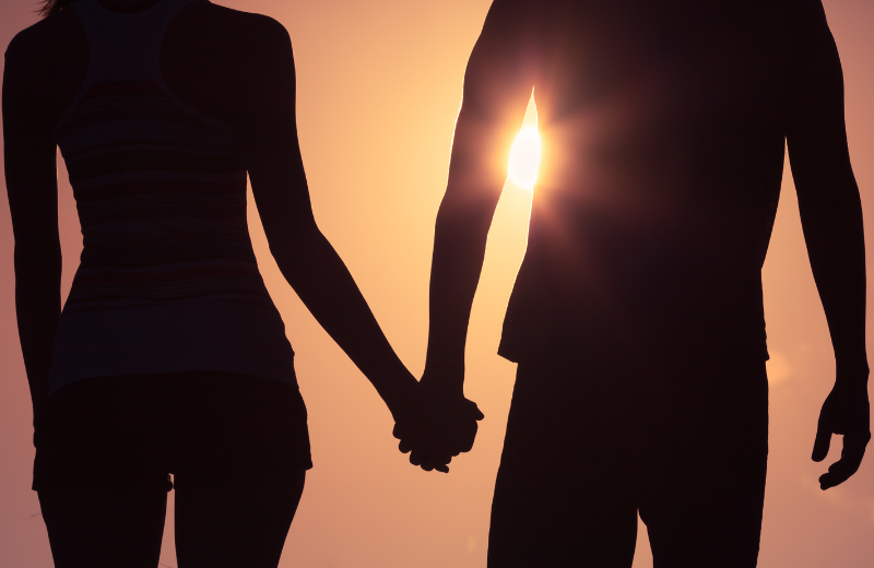 Couple holding hands at sunset