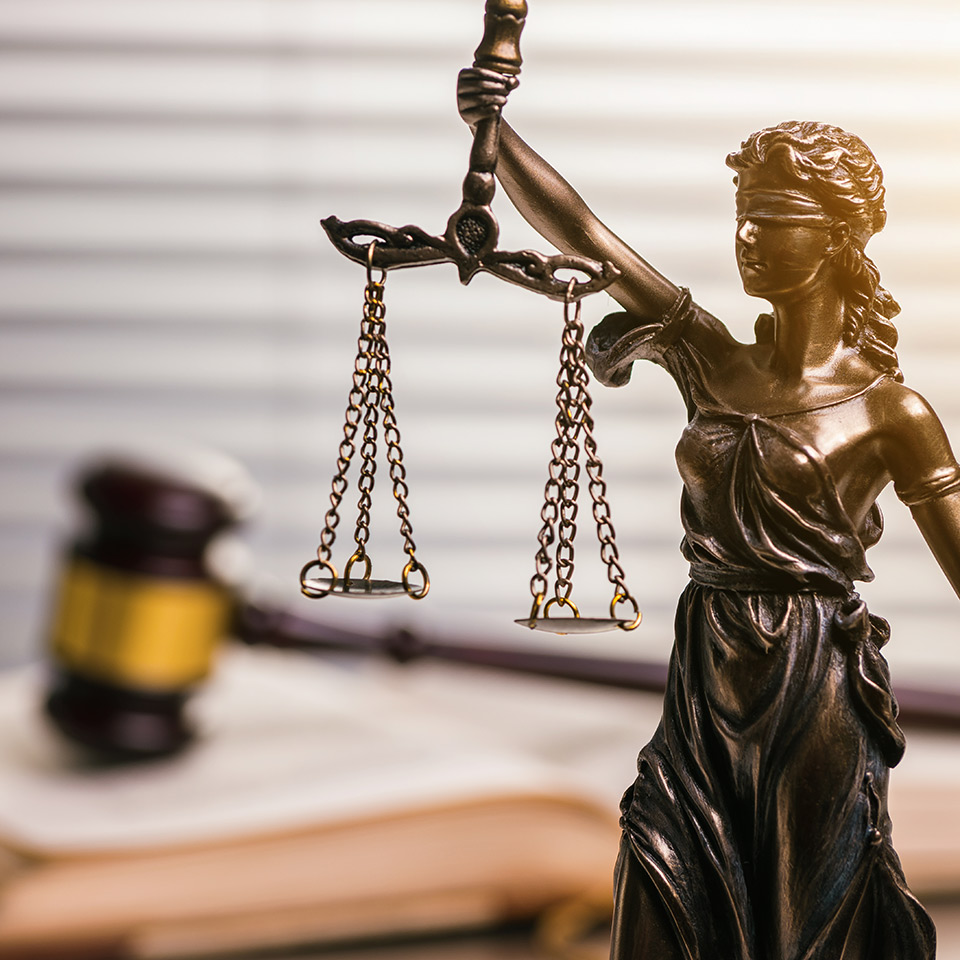 A statue of justice in front of a judge's gavel