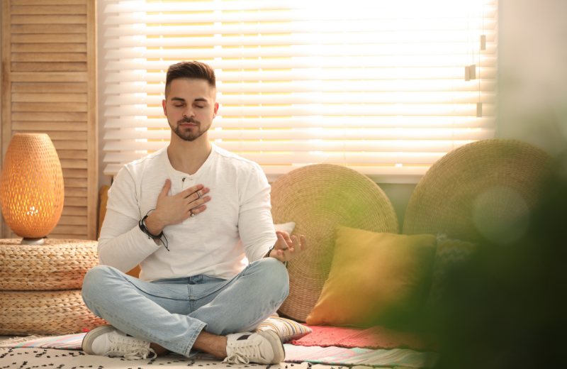 Man meditating in sunlit room