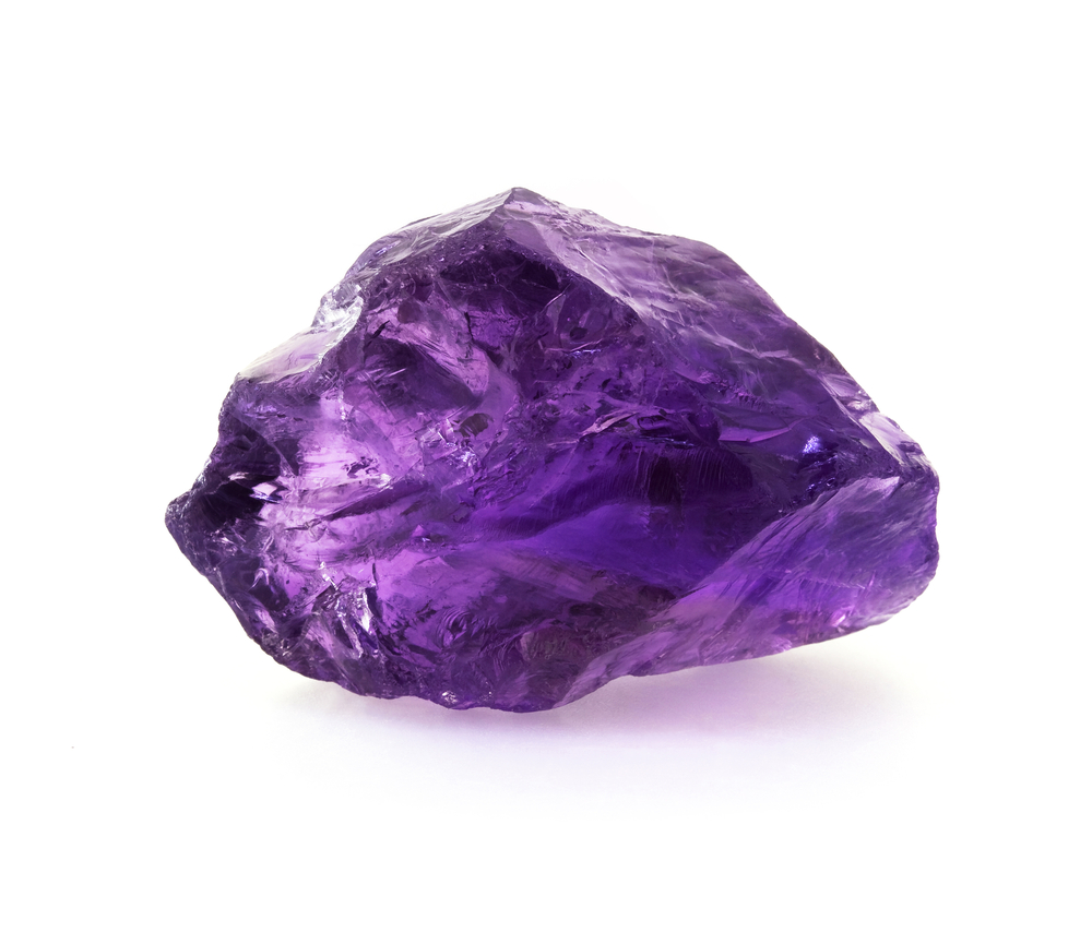 A raw piece of Amethyst on a white background