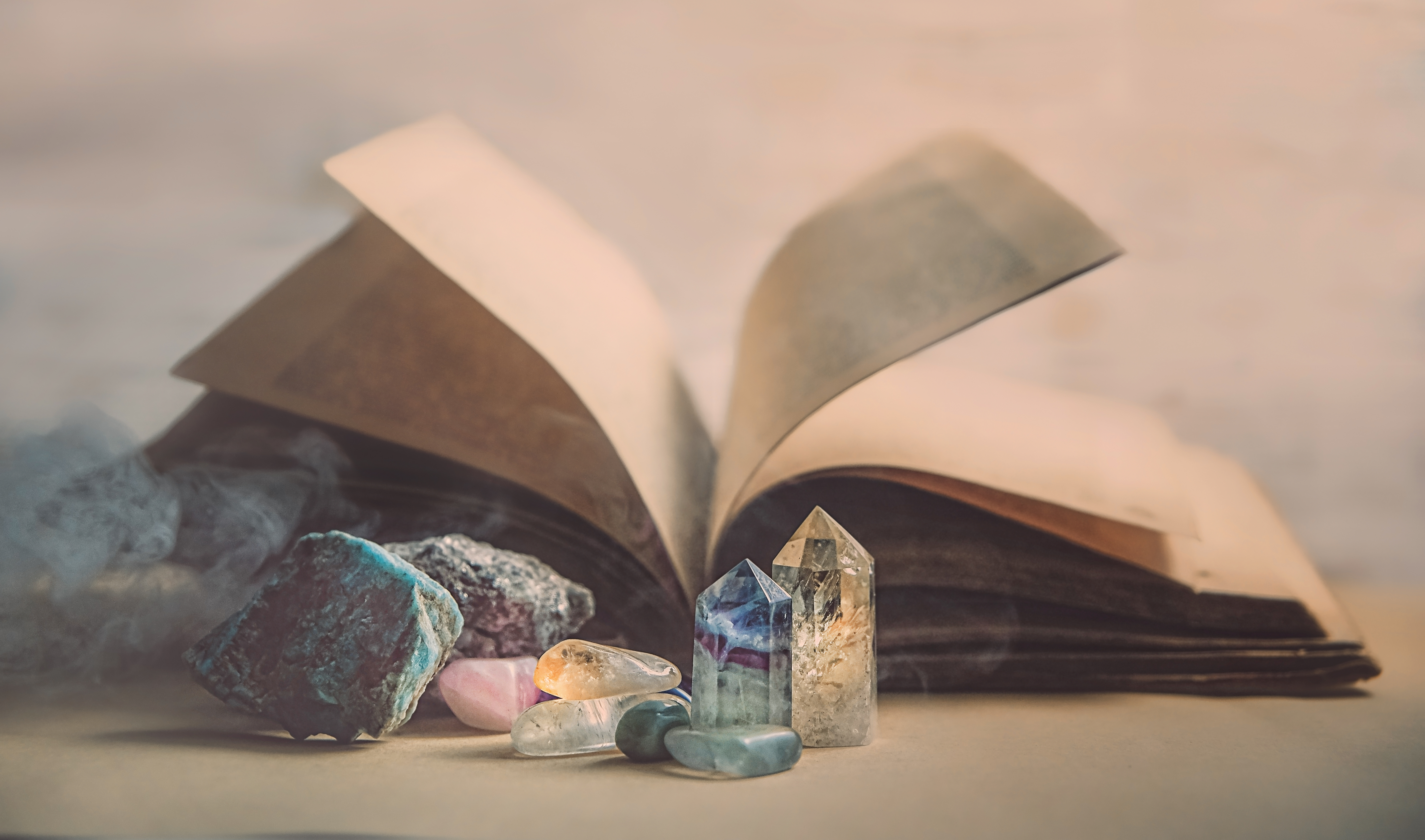 An open book with crystals in front