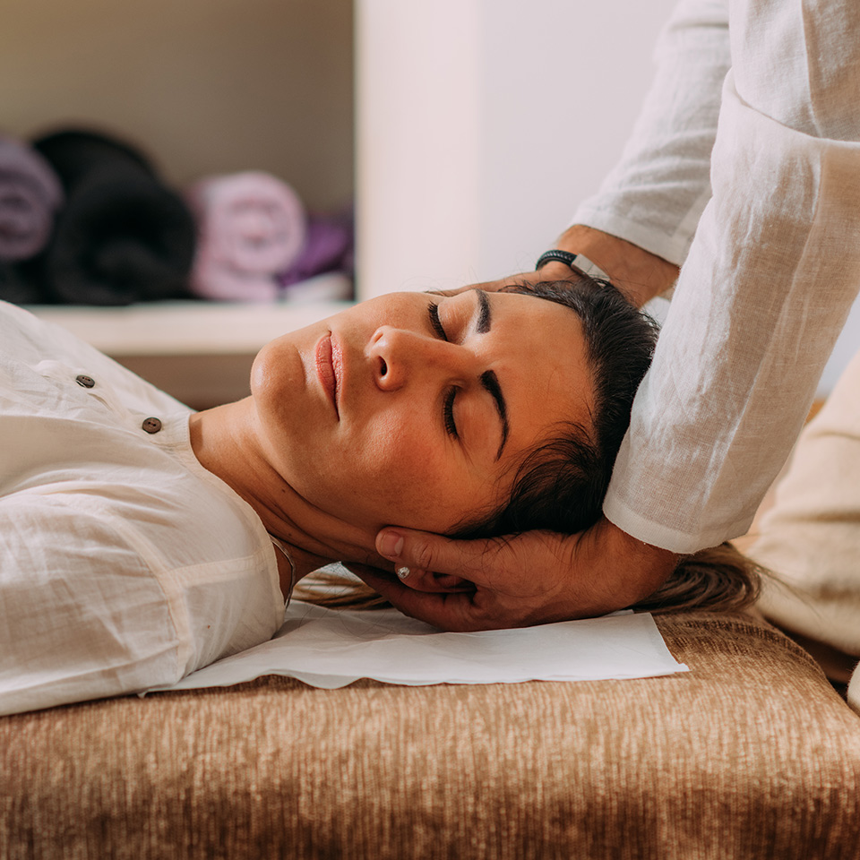 Therapist stretching a woman’s neck during a Shiatsu massage