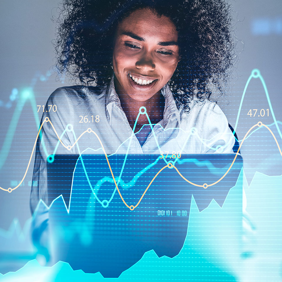 Woman using a laptop with a double exposure of a financial graph