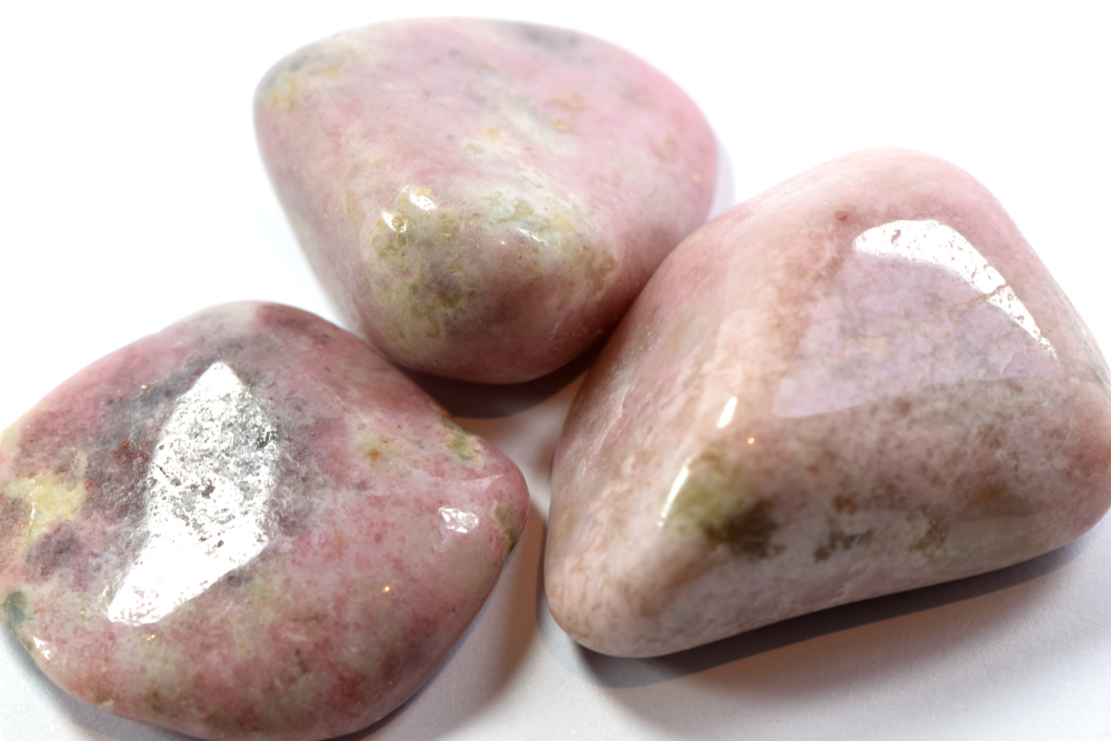 Three pieces of Thulite on a white background