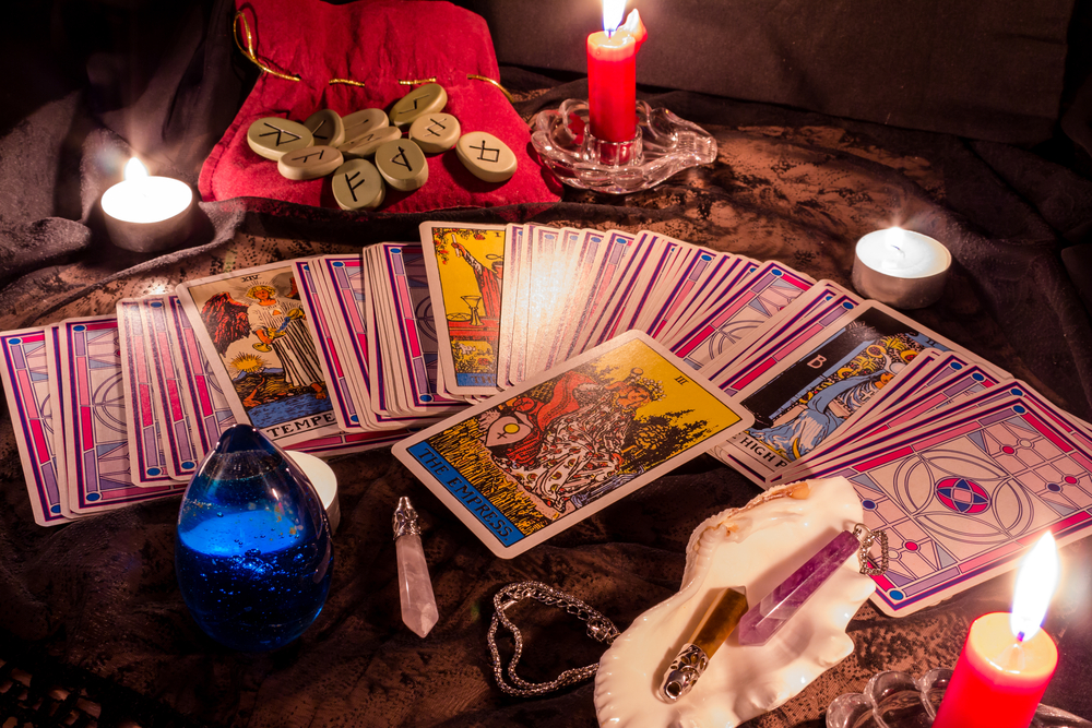 Tarot cards spread out on a table with crystals and candles
