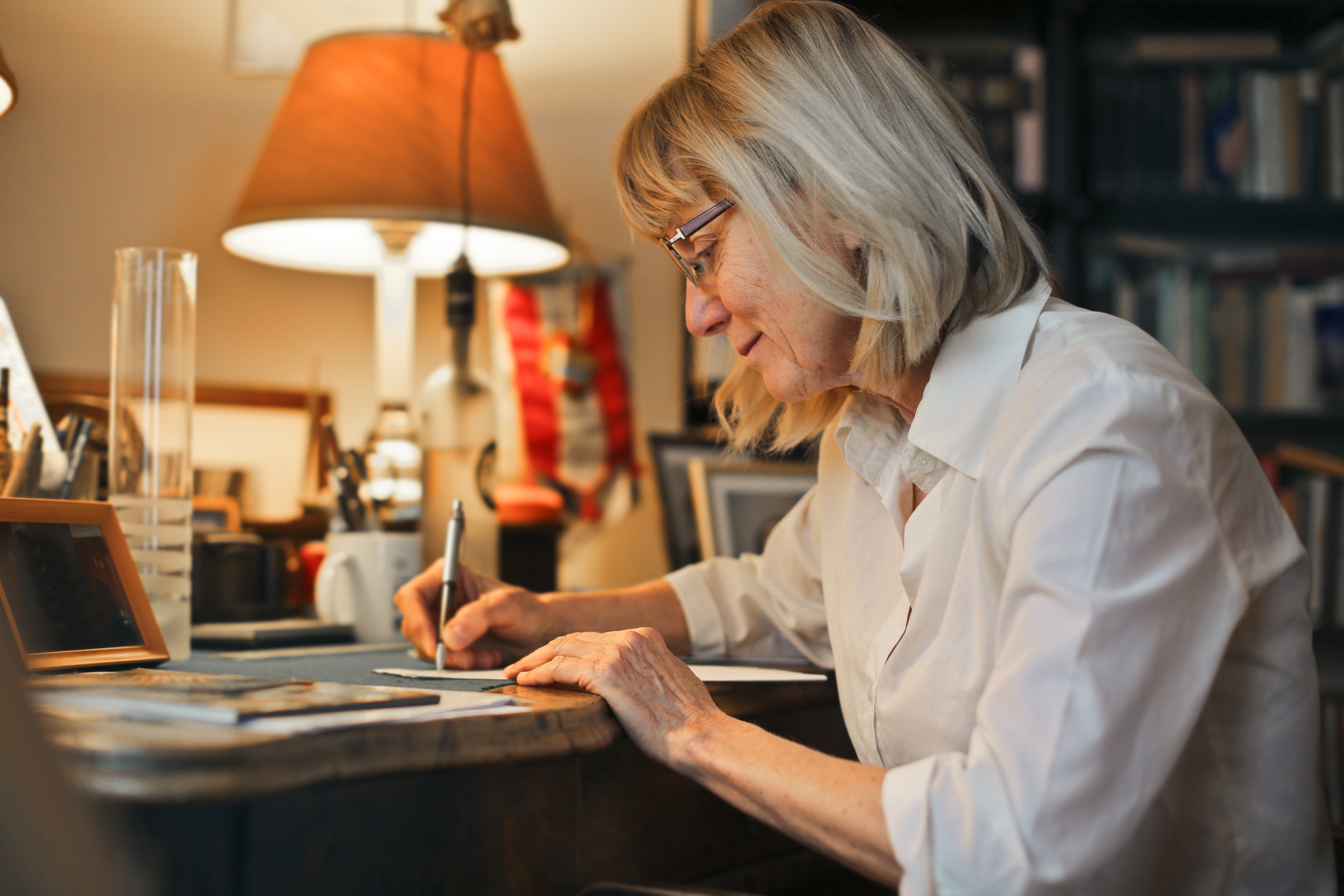 An Someone sitting at a desk writing