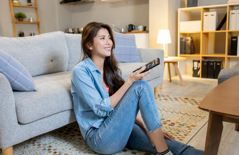 Image of a woman sitting alone watching TV.