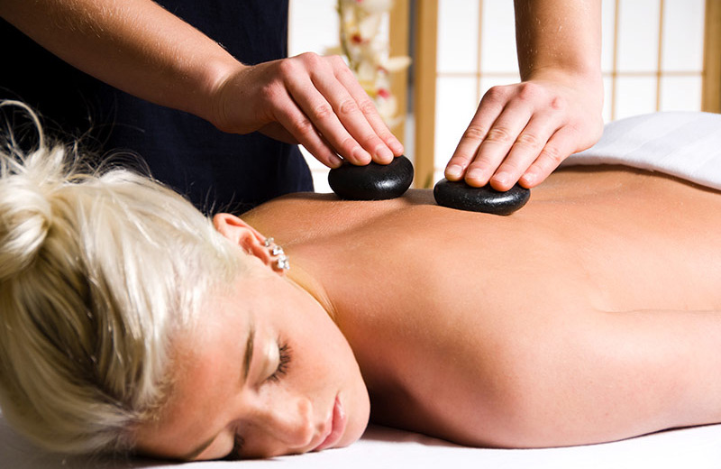 A woman receiving a hot stone massage.