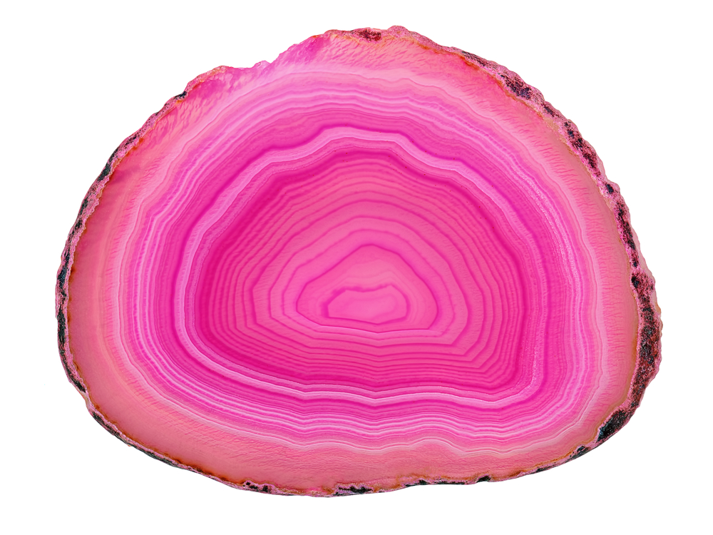The inside of a piece of Pink Agate on a white background