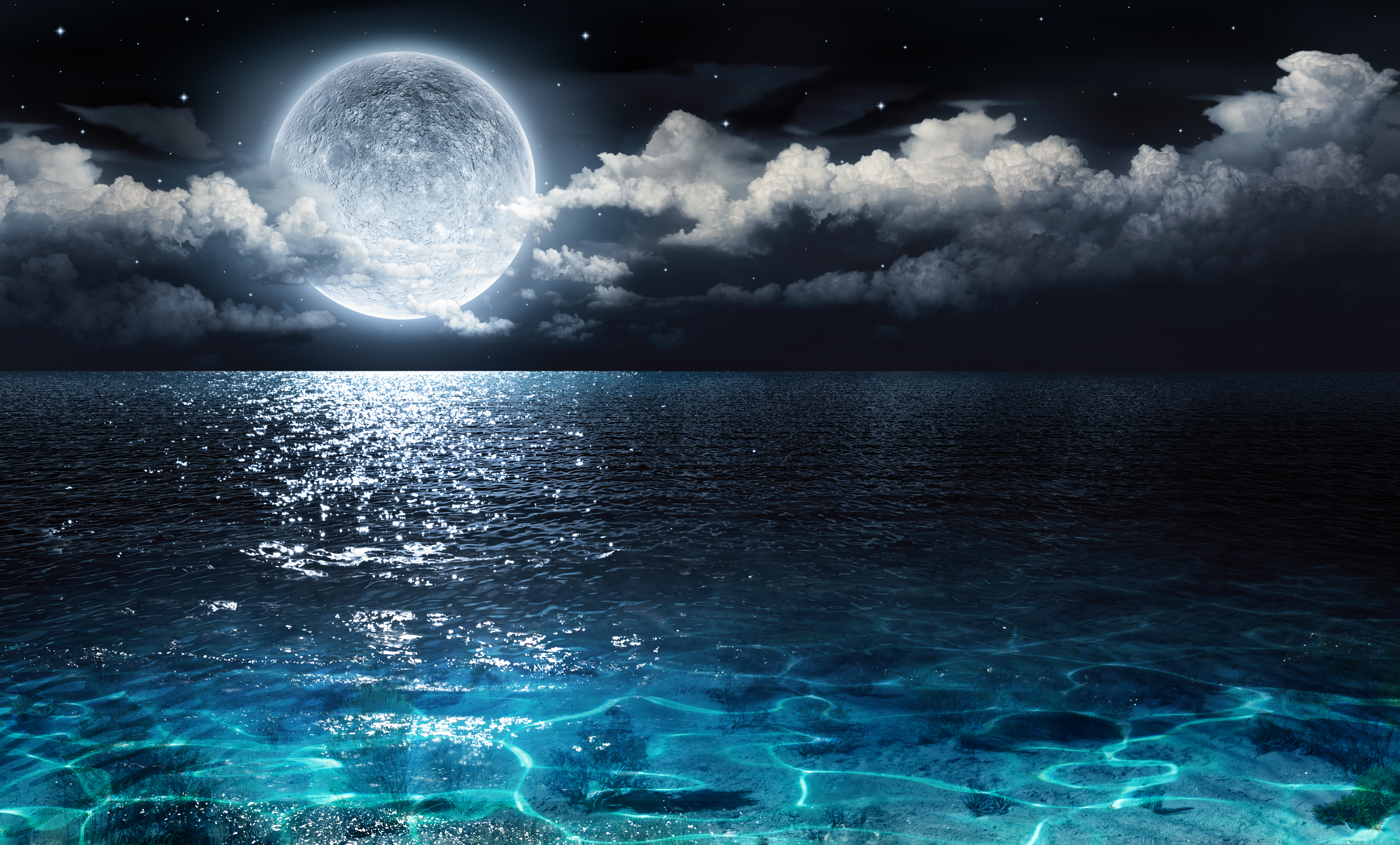Moon in the night sky over water