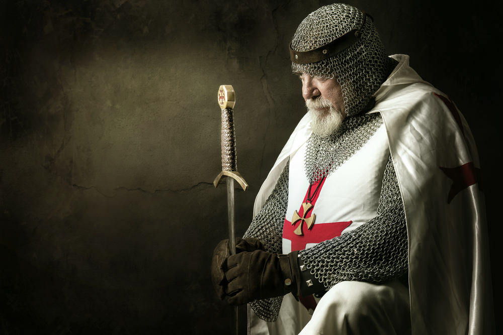 Templar knight with his head bowed slightly, holding a sword