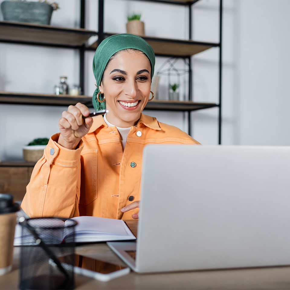 Cheerful person working on maths at a laptop