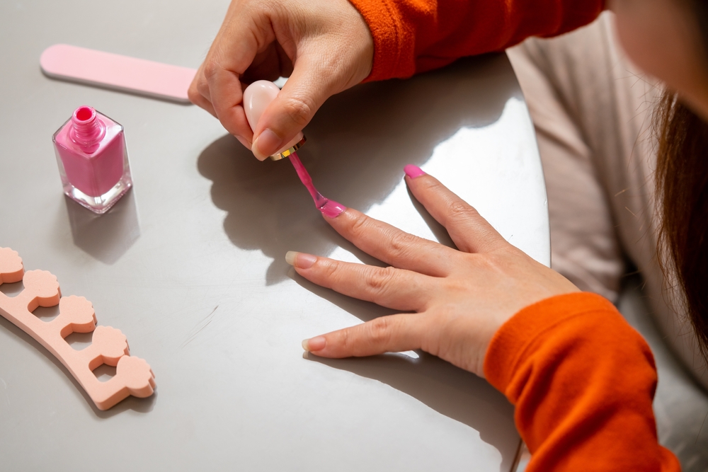 Woman painting nails pink