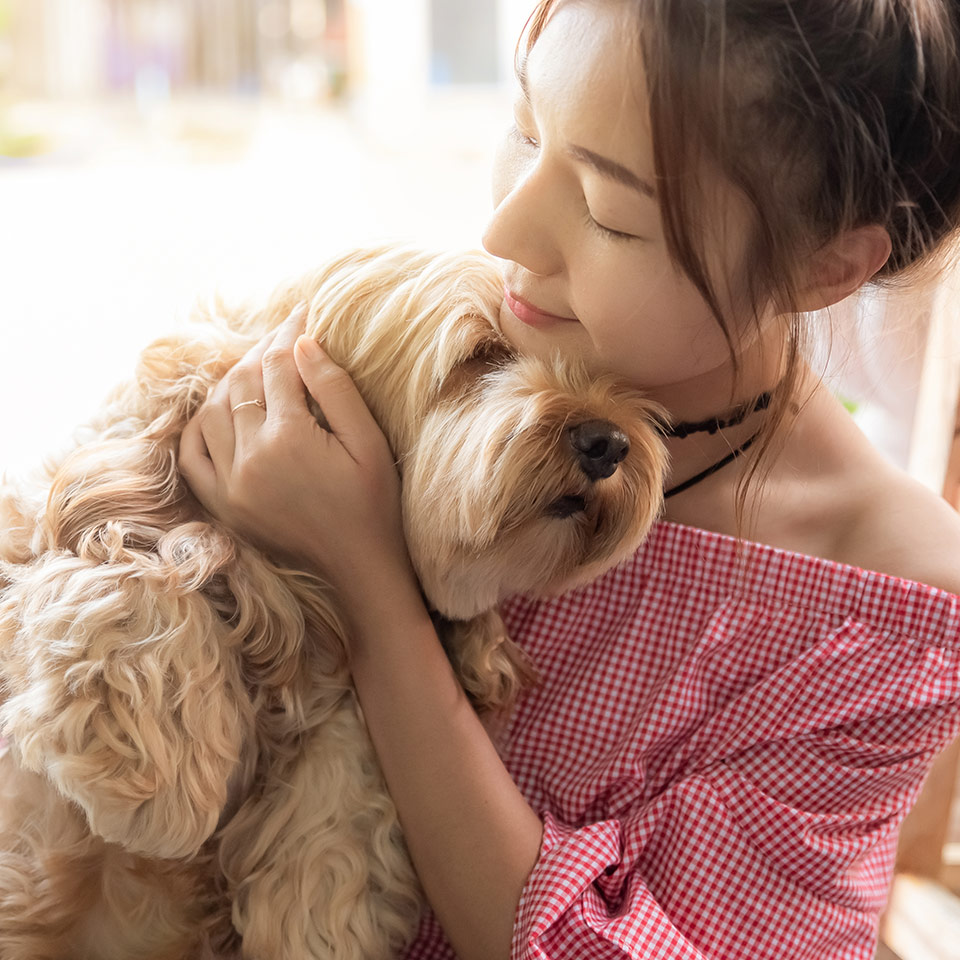 A young woman hugging her dog.