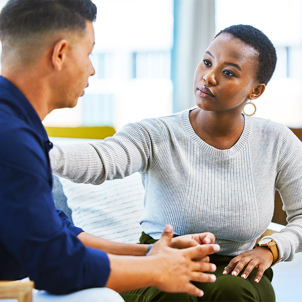 A counsellor resting their hand on the shoulder of a client during a counselling session