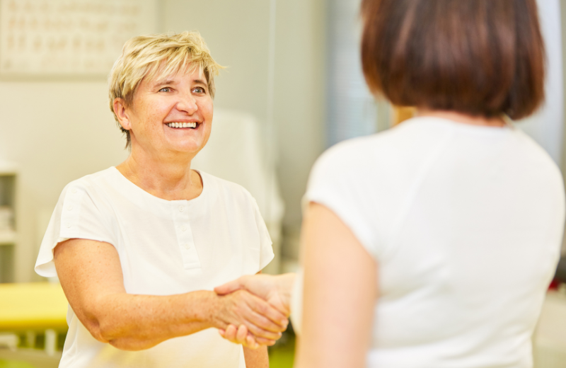 Image of two women shaking hands.