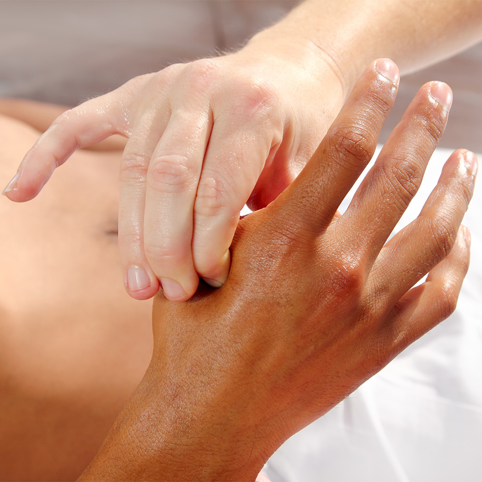 Pressure being applied to a reflex point on a hand
