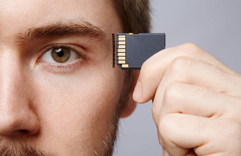 A man holding a micro chip to his forehead illustrating ways to improve memory in this concept art.