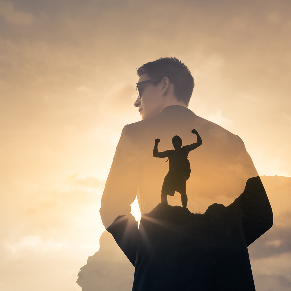Double exposure of a businessman feeling determined and motivated and a climber reaching a summit.