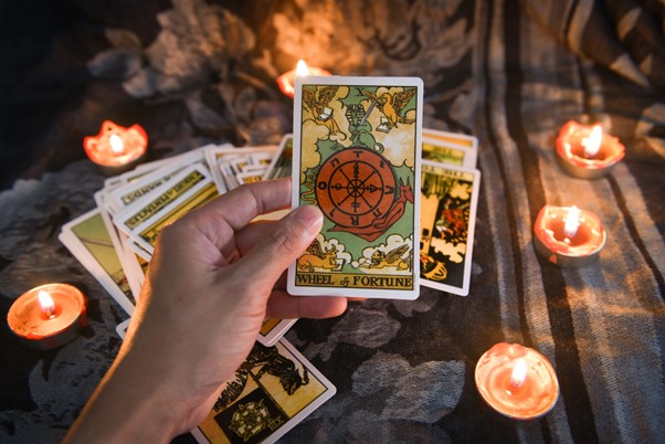 Tarot cards being held in a ring of candles