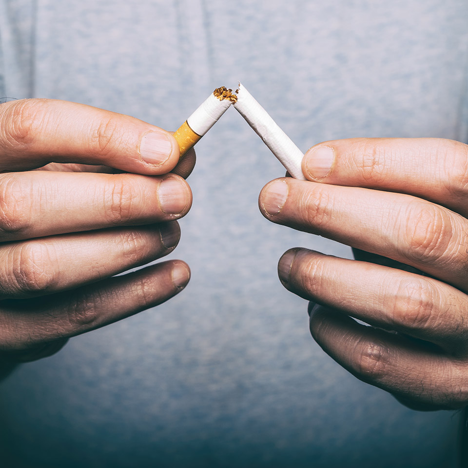 A cigarette being broken in half.