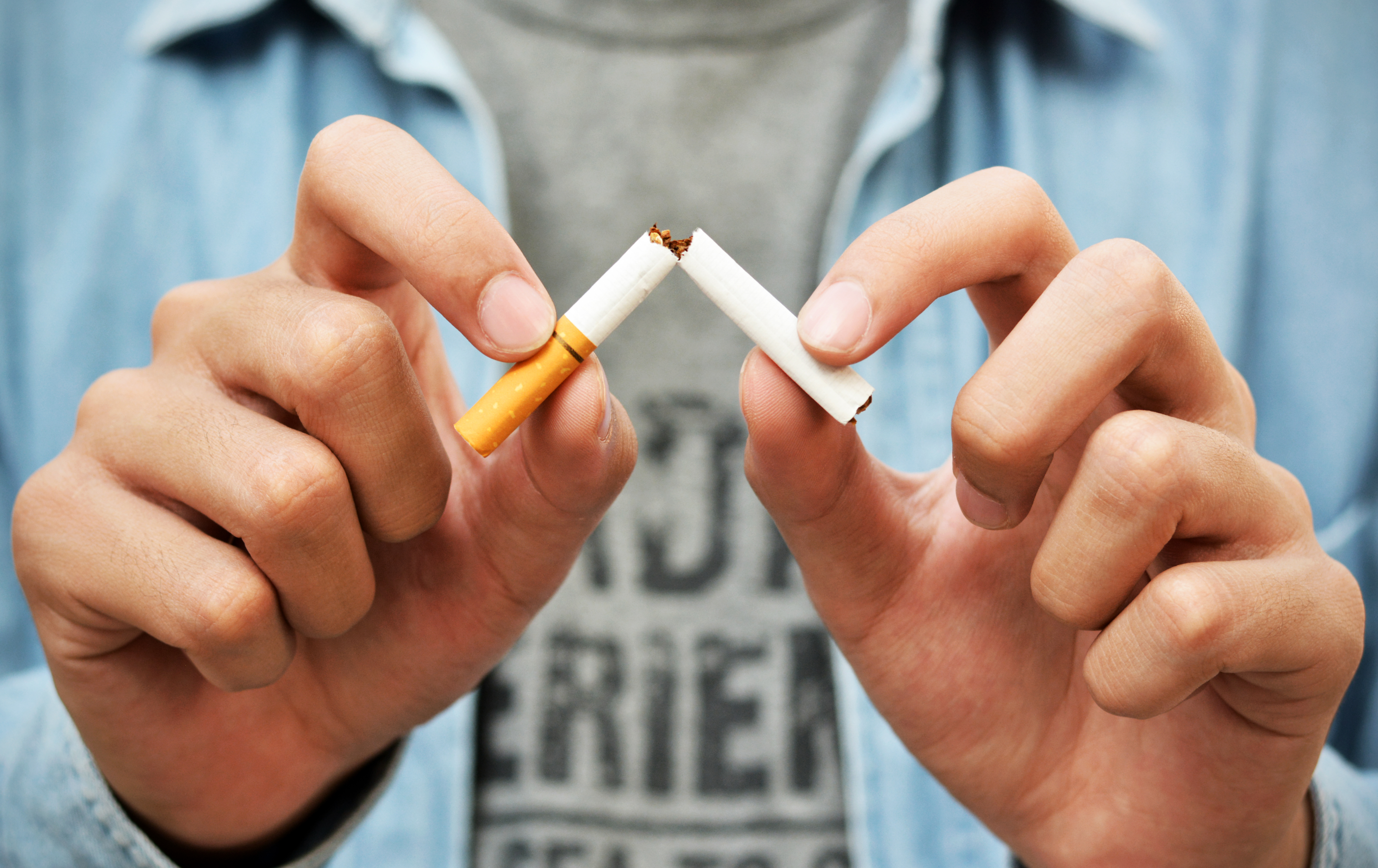 A cigarette being broken into two pieces