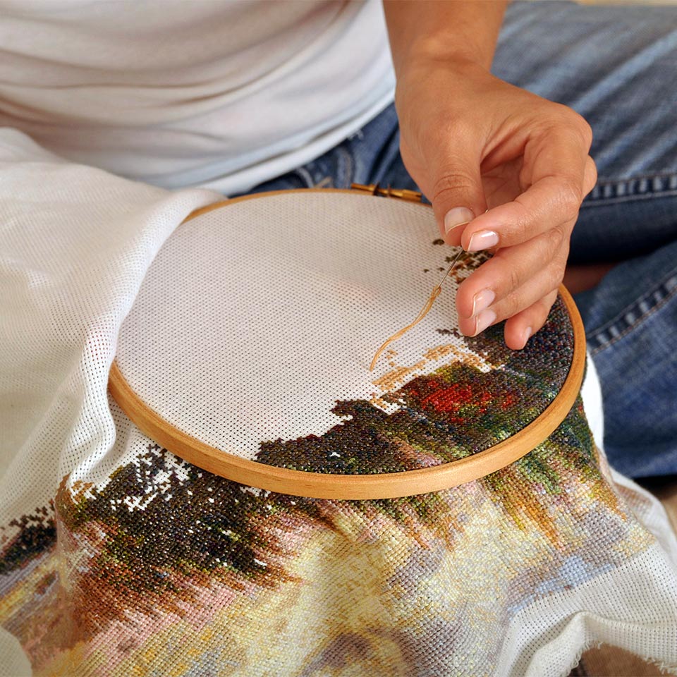Woman working on a cross stitch hoop